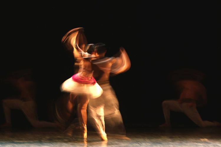 Blurred motion of artists dancing on stage
