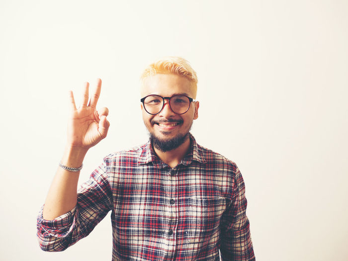 Portrait of smiling young man against white background