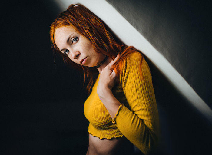 Portrait of woman leaning on wall