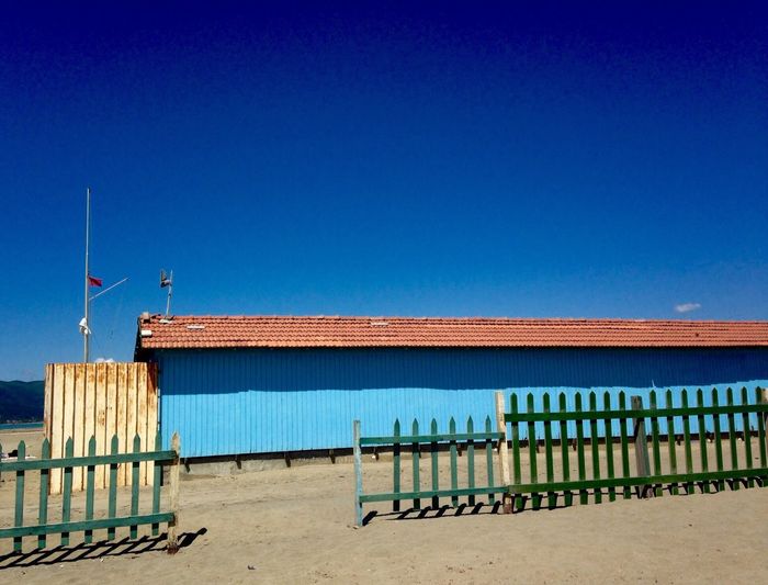 Lifeguard hut on beach against clear blue sky