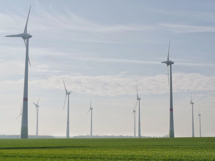 Low angle view of windmill on field against sky