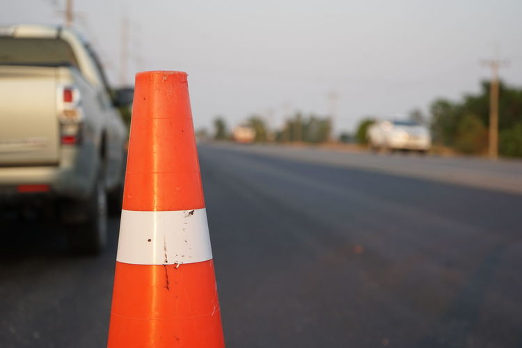 Close-up of orange flag on road in city