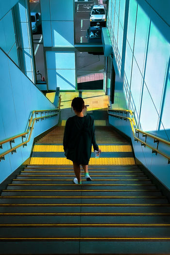 Rear view of woman walking on staircase