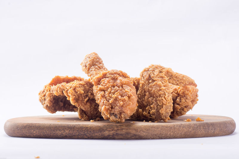 Close-up of crispy fried chicken against white background