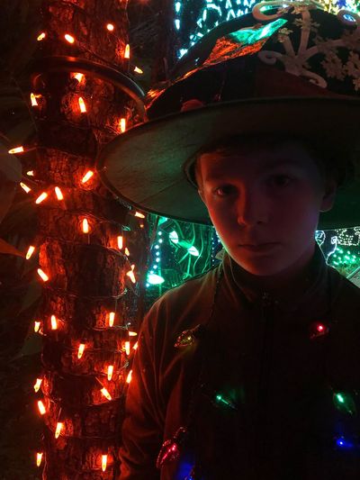 Portrait of man with illuminated christmas lights