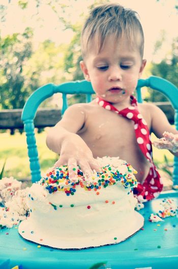 Close-up of shirtless boy with birthday cake
