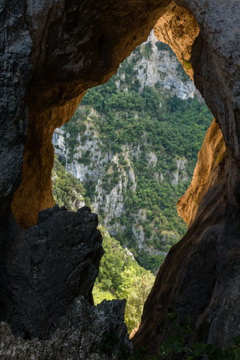 Scenic view of mountain seen through cave
