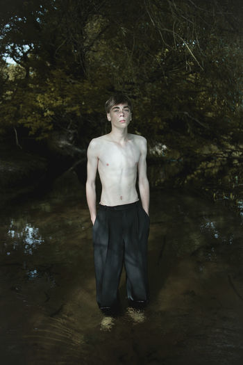 Portrait of young man standing in lake