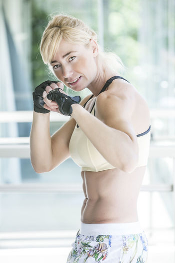 Side view portrait of female athlete standing in gym