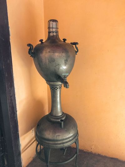 Close-up of electric lamp on table against wall