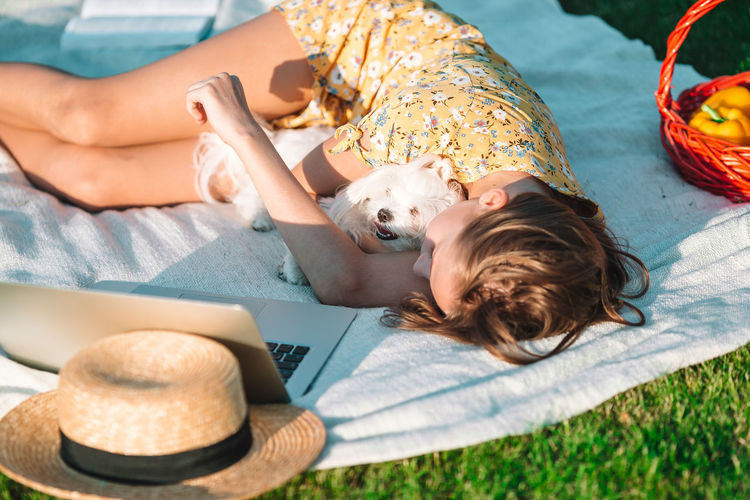 Midsection of woman and dog lying on floor