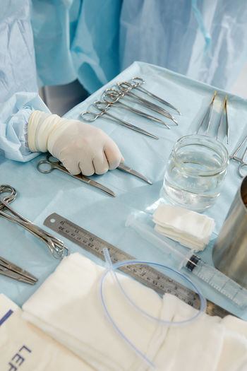 Midsection of surgeon holding tools