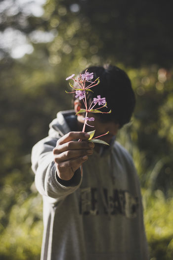 Close-up of man giving flowers