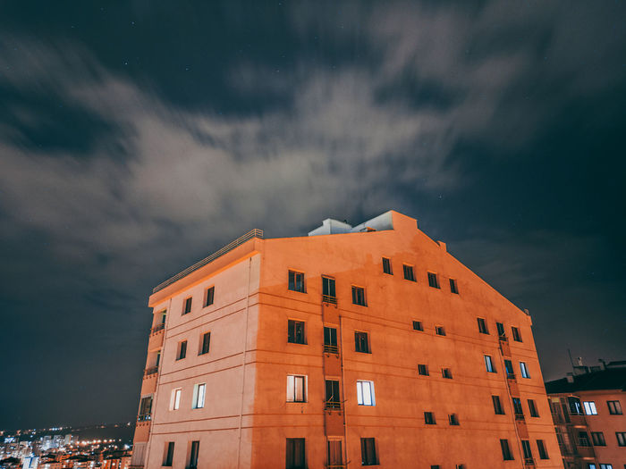 Low angle view of buildings against sky at night