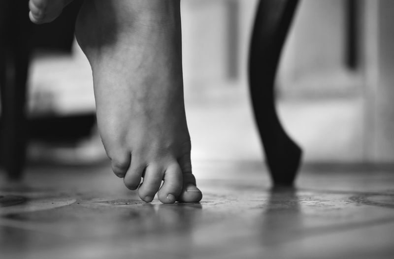 Low section of person tiptoe on floor