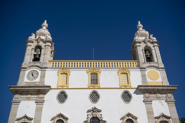Low angle view of igreja do carmo against clear blue sky at faro