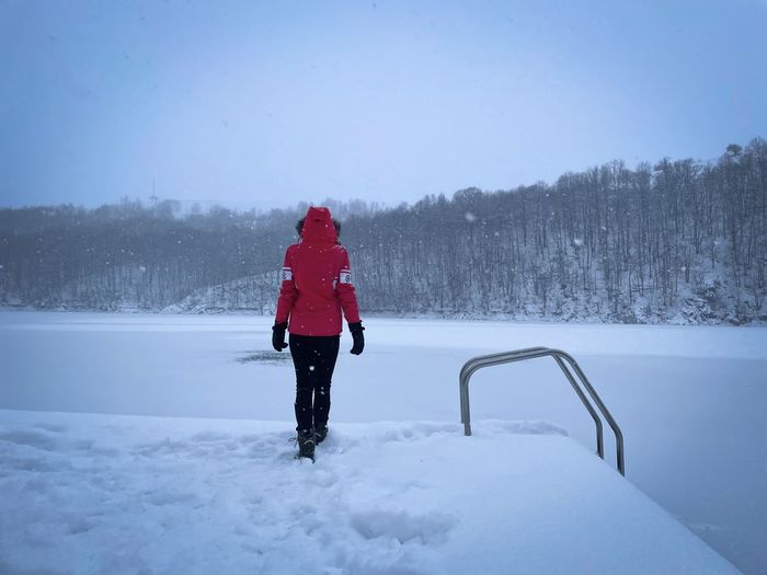 Full length of man walking on snow covered landscape
