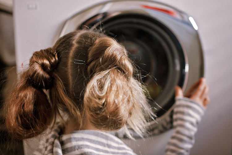 Teenage girl using common laundry to save resources and money. sustainability and environment care