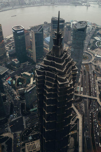 From above aerial view of famous landmark skyscraper jin mao tower located among contemporary high rise buildings at river waterfront in shanghai