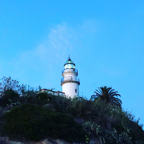 Low angle view of lighthouse against buildings