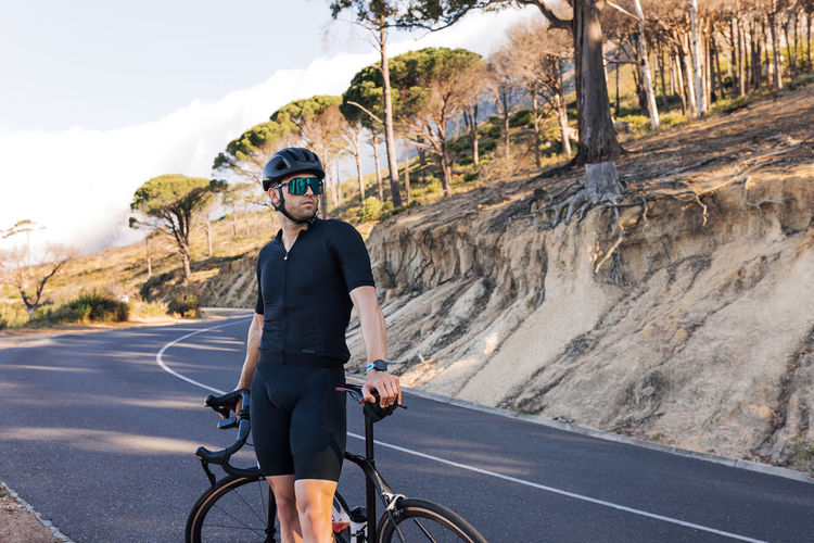Rear view of man riding bicycle on mountain