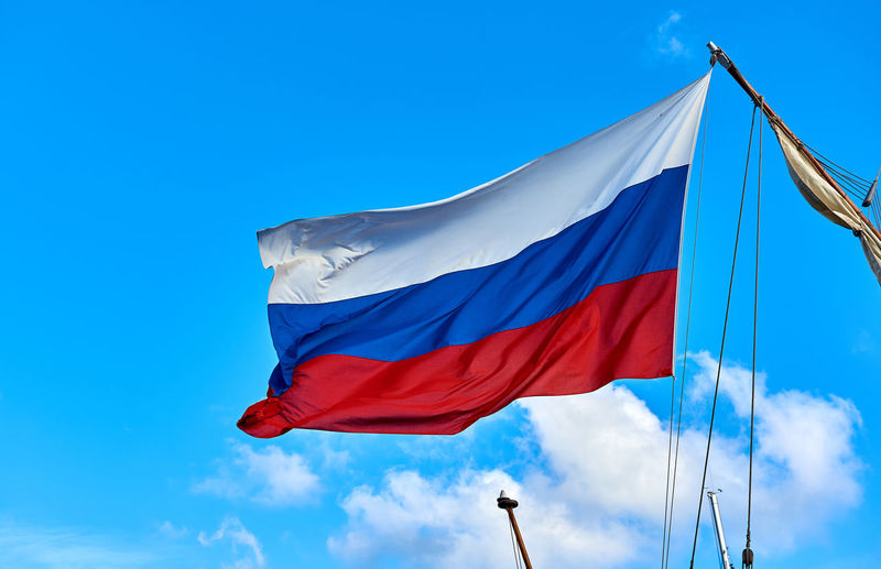 Low angle view of russian flag against blue sky during sunny day