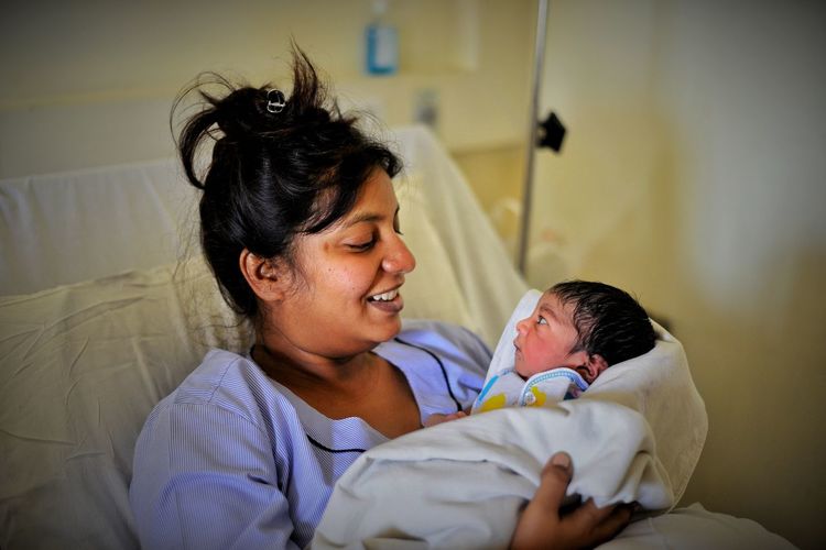Cheerful mother with newborn baby