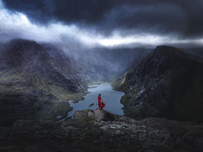 Man walking on rocks by mountain