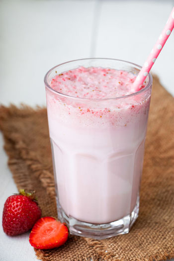 Cold milkshake with strawberries on a white background. summer drink in a glass 