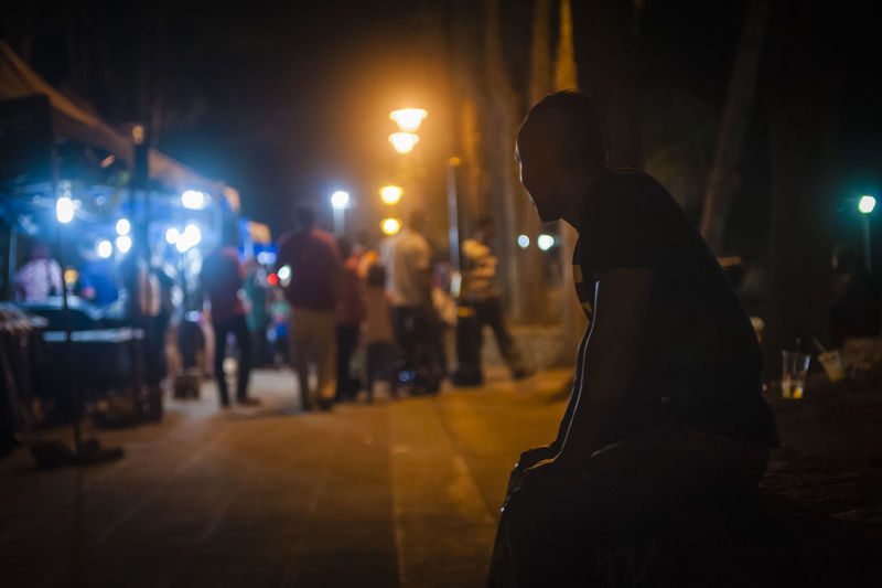 Man sitting at night street market