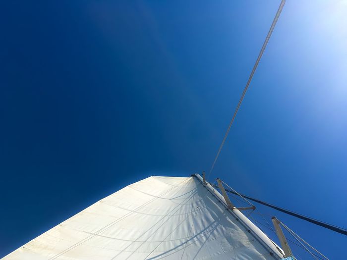 Mast and canvas of sailboat against sky