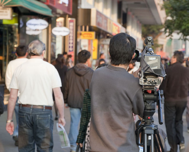 Rear view of people walking on city street