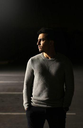 Young man standing outdoors at night