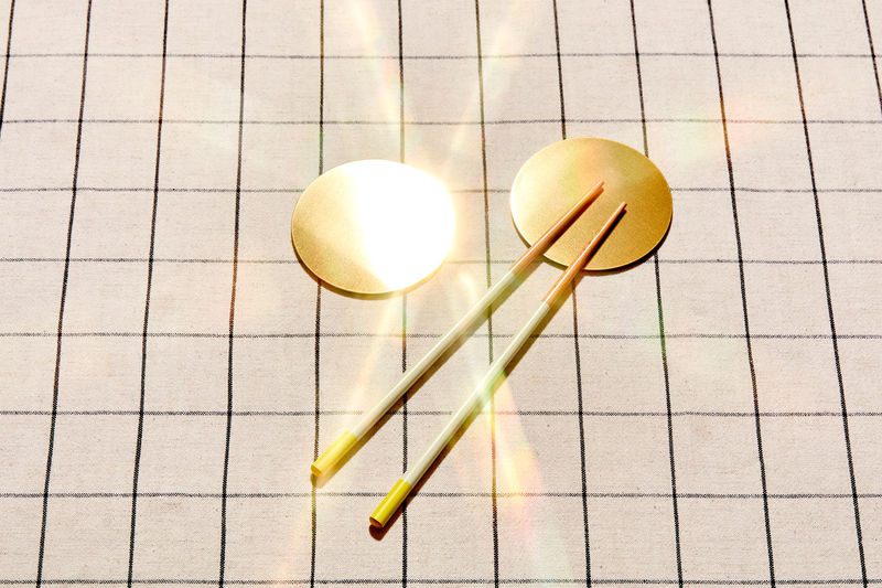 Two golden coasters with chopsticks
