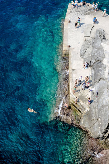 High angle view of people on rock by sea