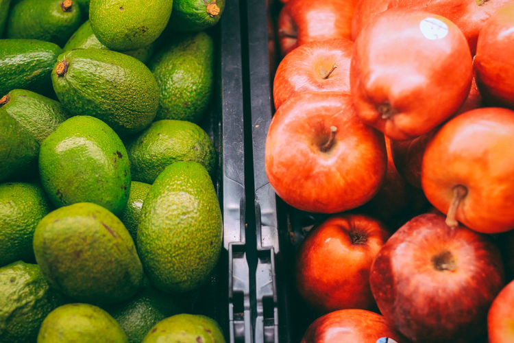 Apples and avocado at market for sale