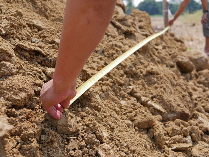 Cropped hand measuring soil