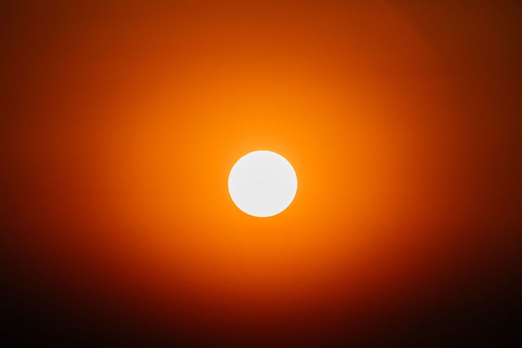 Low angle view of sun against orange sky
