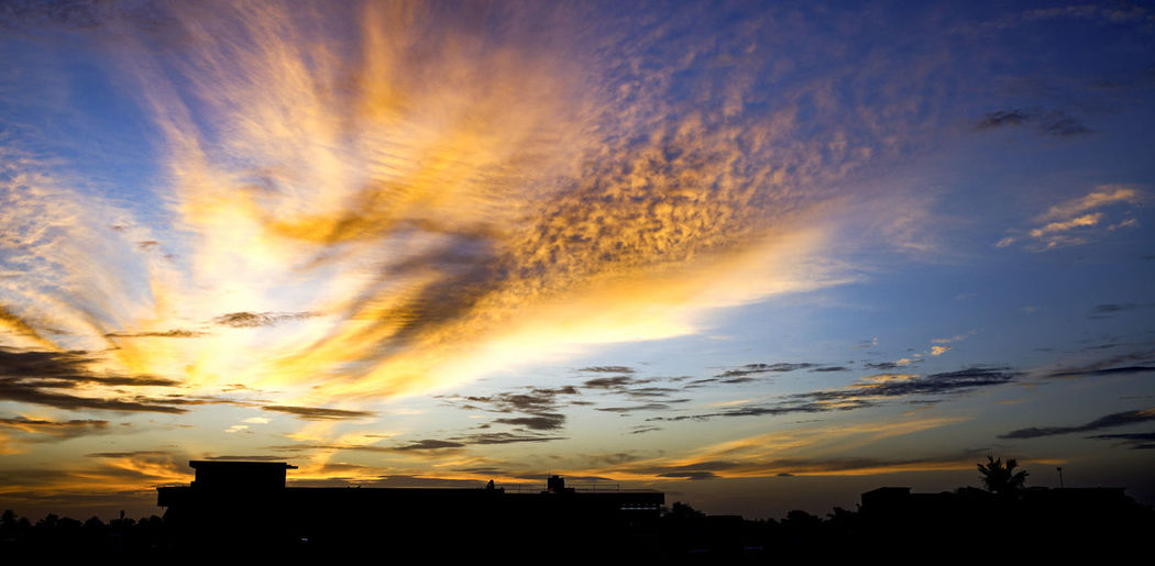 Low angle view of silhouette buildings against sky during sunset
