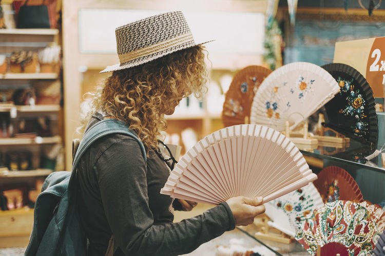 Rear view of woman holding hat