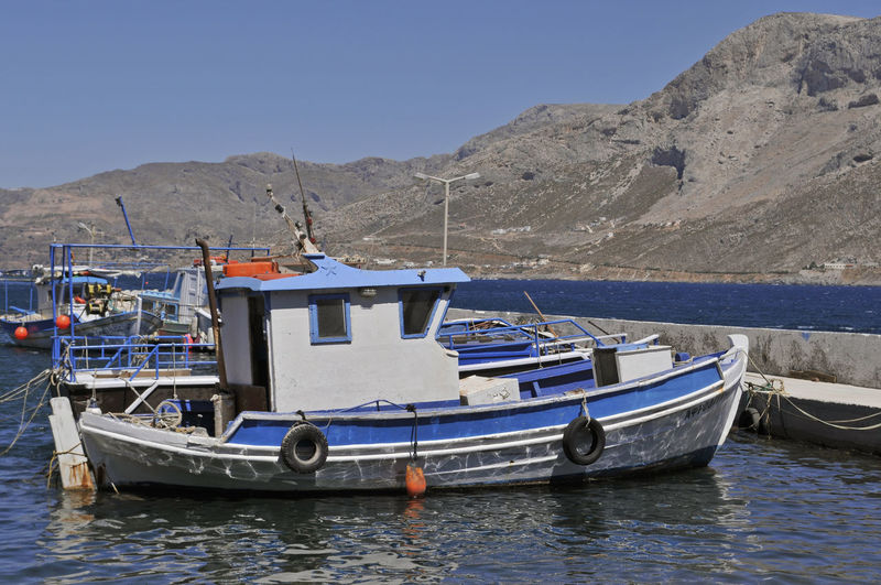 Boats moored along pier in greece