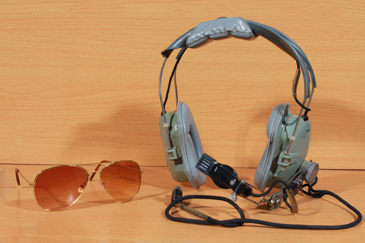 Close-up of headset and aviator glasses on table