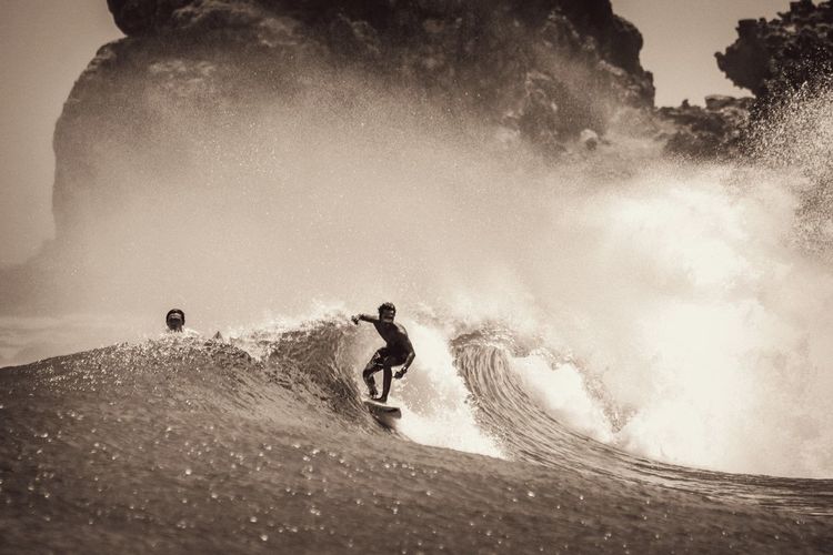 Man surfing in the ocean against sky