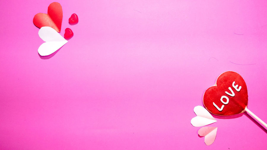 Close-up of heart shape made on pink background