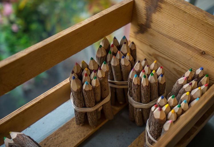High angle view of colored pencils in wooden crate