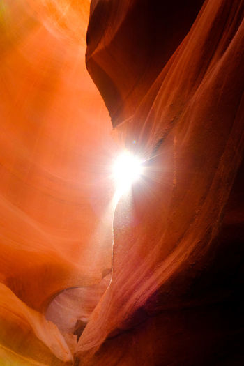 Low angle view of sunlight streaming through rocks
