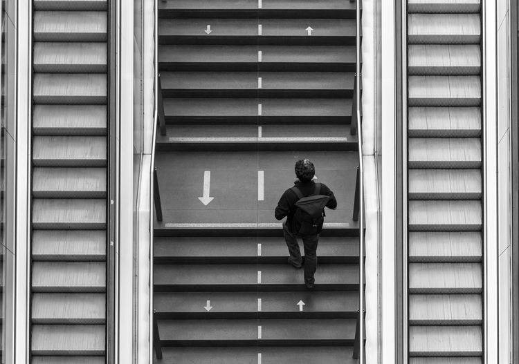 Low angle view of man walking on staircase of building