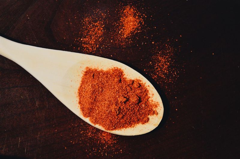 High angle view of red chili powder in spoon on table