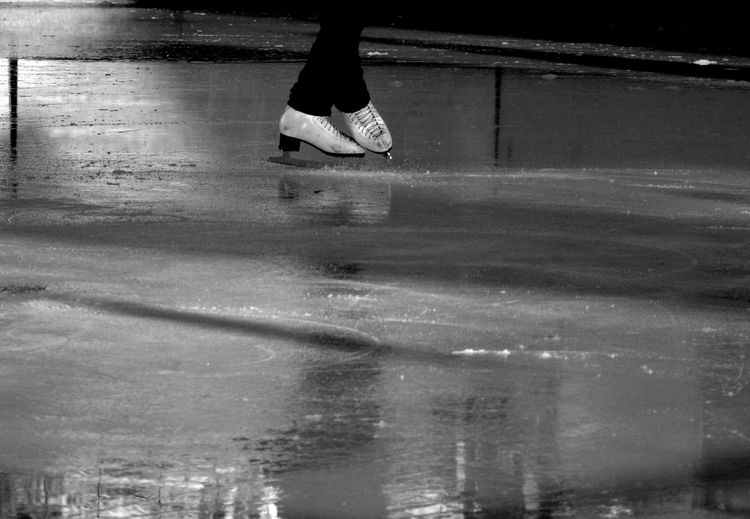 Low section of person ice skating in rink