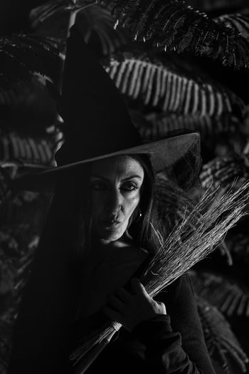 Close-up of mid adult woman in witch costume standing outdoors during halloween